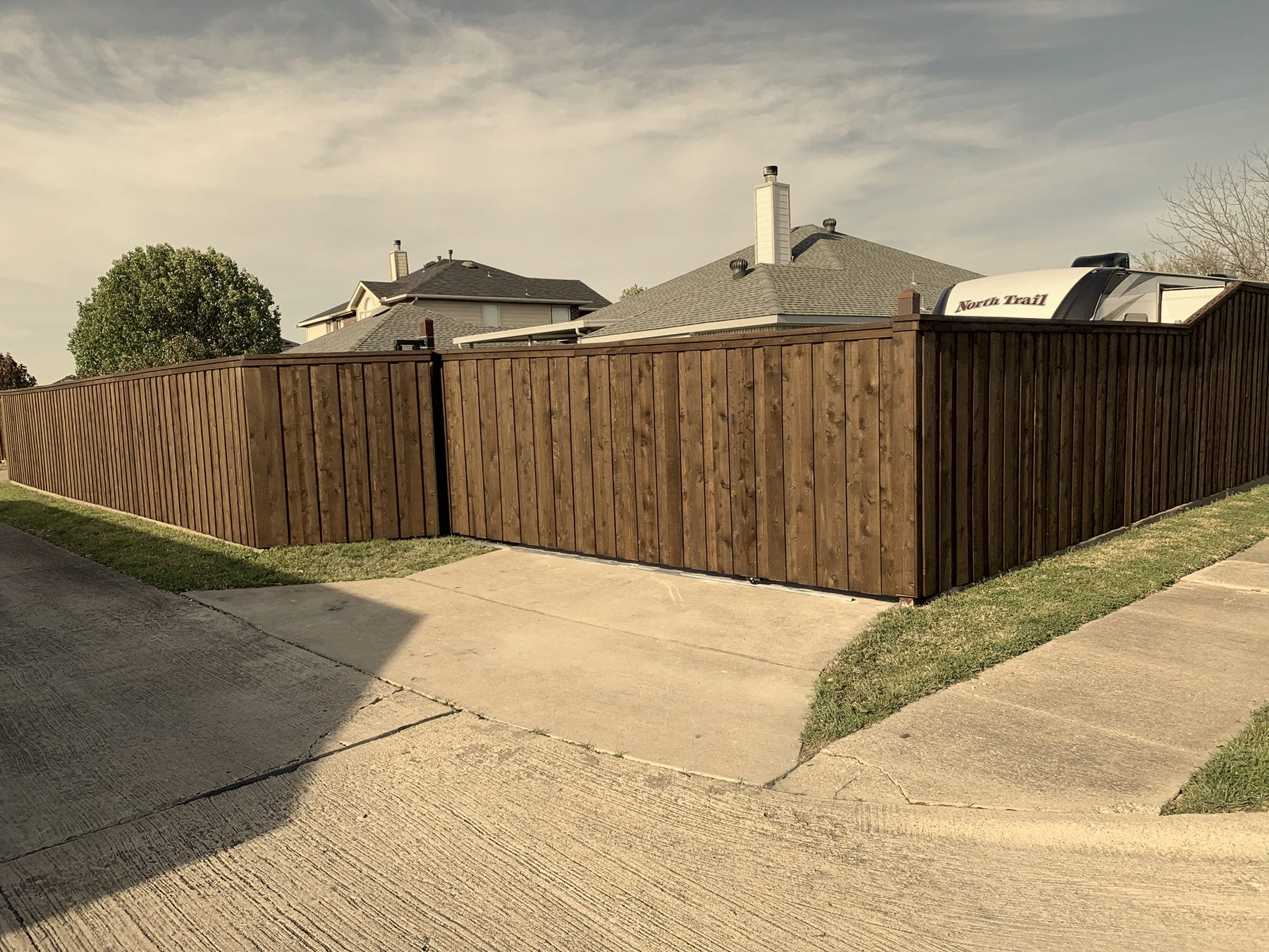 Stained cedar board-on-board fence and gate on a corner lot in the Dallas–Fort Worth Metroplex