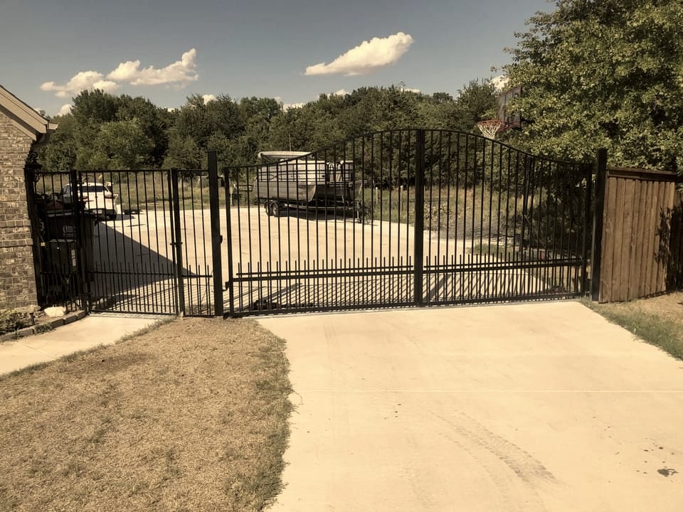 Black wrought iron arched driveway gate built and installed by A+ Fence Company