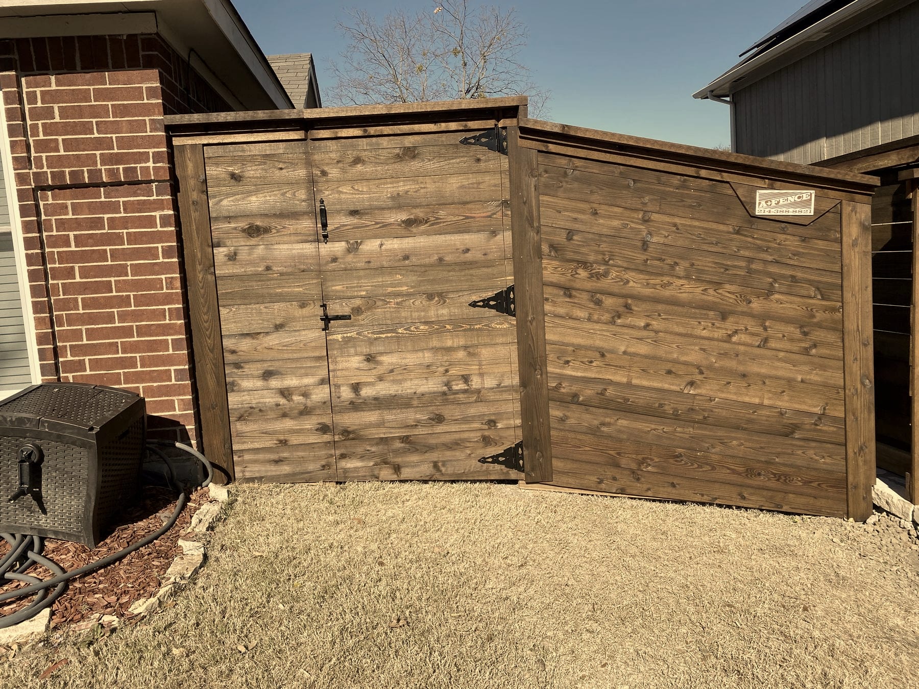 Cedar fence and gate with decorative black hinges built by A+ Fence Company
